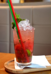Mojito cocktail on a glass on a wooden table.