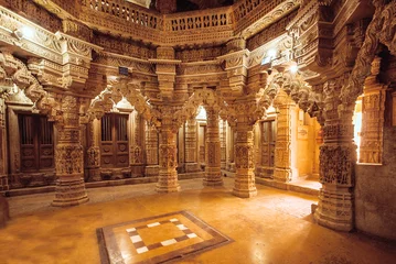Peel and stick wallpaper Place of worship Columns with stone reliefs in Indian temple wall. Ancient architecture example with Jain motifs, Jaisalmer of India.