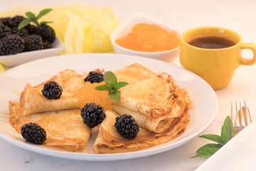 Serving French Crepes with fresh berries and honey on the plate.  Close up.