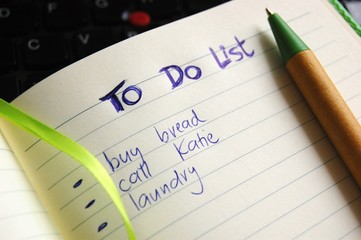 to do list hand written with a pen and computer in the background - 174589177
