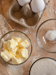 Baking ingredients on kitchen table. White products prepare for cooking on wooden cutting board. Lifestile food concept.