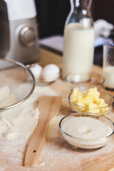 Baking ingredients on kitchen table. White products prepare for cooking on wooden cutting board. Lifestile food concept.