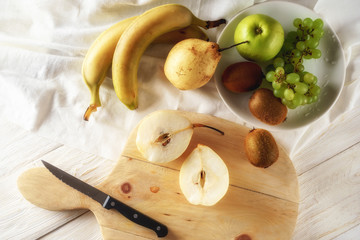 Ingredients for fruit salad. Cutting pears