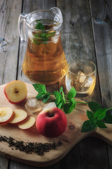 Tea in a jar and sliced apples on a cutting board