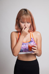 Beautiful healthy Asian girl hate  tomato juice.