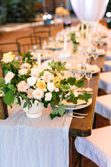 floral design, decoration, ornamental plants concept. at the head of the table there is gorgeous bouquet of ideal roses avalanches made in bouquet with brunches of oak and rosebush