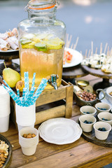 food, drink, selling concept. multinational dishes represented by rolls, sushi, fruits and disperce variety of nuts in the paper cups placed on the wooden table, served for lots of people