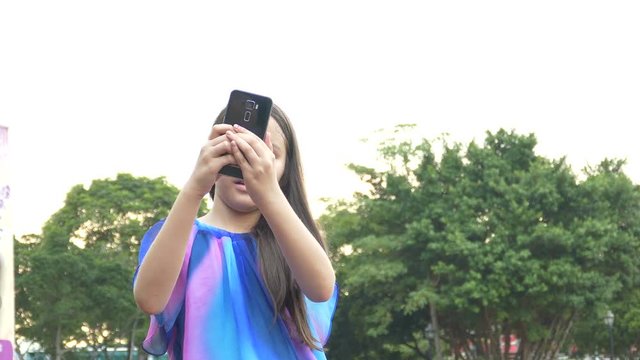 Young tween girl taking selfie with smartphone