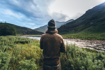 hiker outdoorsman standing in a mountain wilderness