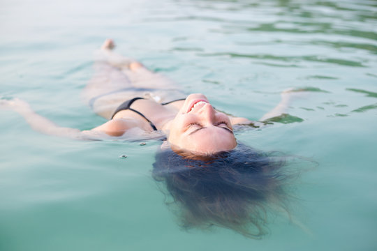 Beautiful young woman floating in the sea relaxing
