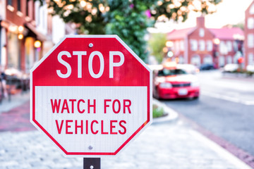 Stop Watch For Vehicles red street sign on Georgetown neighborhood of Washington DC downtown street...