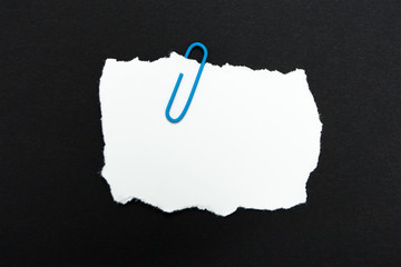 A memo paper clip with a paper clip on a black background.