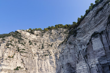 Limestone Cliffs With Trees On Top Against Clear Blue Sky