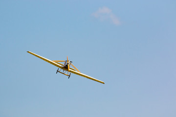Fototapeta premium Vintage żółty samolot w błękitne niebo, na tle nieba