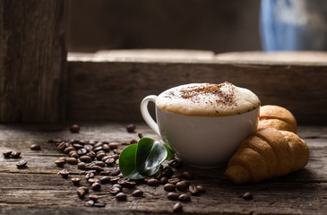 A cup of coffee with the branches of the Christmas tree on a wooden table