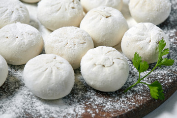 Khinkali on wooden plate with flour. Pelmeni
