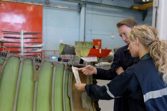 Maintenance engineers working over an aircraft panel