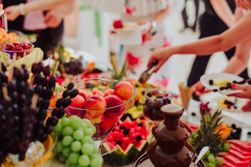 Chocolate Fountain And Fruits For Dessert At Wedding Table