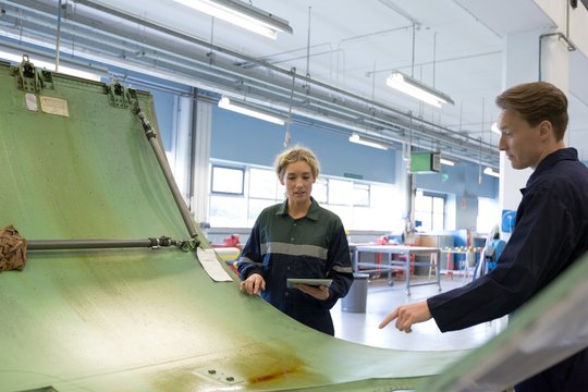 Maintenance engineers working over an aircraft panel
