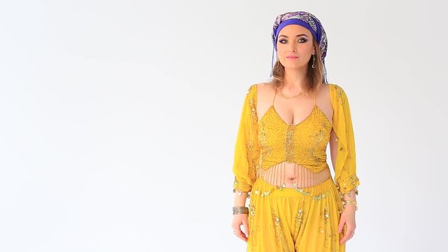 Beautiful arabian girl in national clothing, showing something in white studio backgraund 