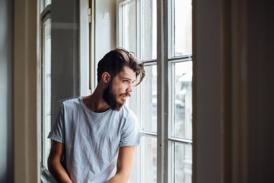 Handsome Bearded Man Looking Thought the Window
