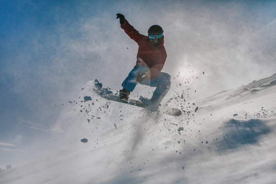   snowboarder jumping down the hill