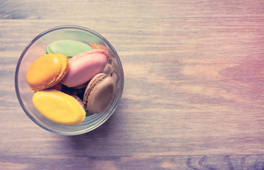 French dessert multicolored macaroni on a brown wooden table