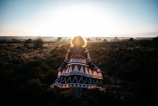 A woman walking in the heath in sunset light