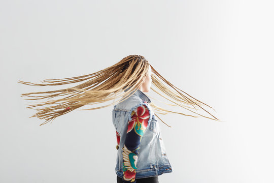 Young African-American woman with braider hair on white background