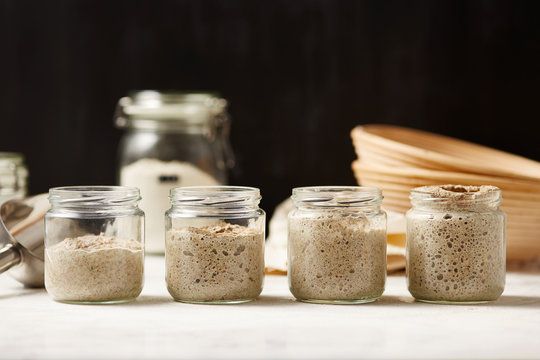 Four glass jars with sourdough