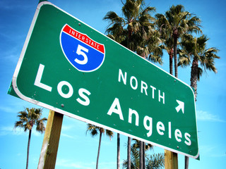 Los Angeles freeway sign with palm trees - Powered by Adobe