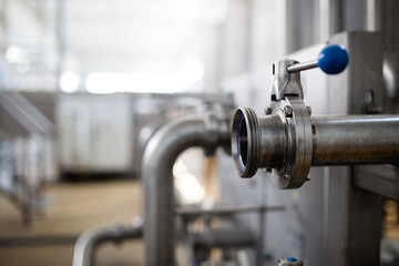 Fototapeta premium Close up details from factory for purification and bottling of drinking water into bottles and canisters. Pipes and valves.