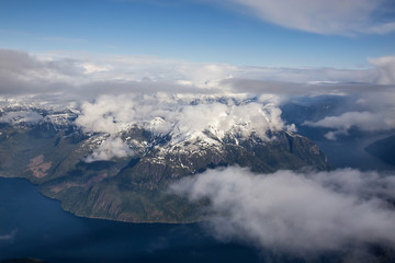 Fototapeta na wymiar Marlborough Peak around Jervis Inlet, North of Sunshine Coast, British Columbia, Canada. Taken from an Aerial Perspective during a cloudy evening.