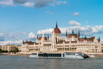 Fototapeta na wymiar The Hungarian Parliament Building on the bank of the Danube in Budapest. Sunny day with clouds