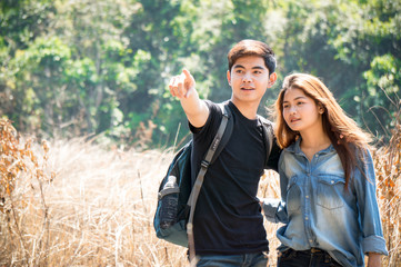 Asian travelers as couple pointing to target in autumn forest