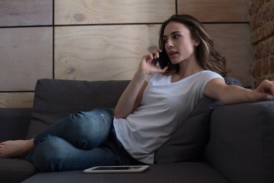 Woman talking mobile phone at home