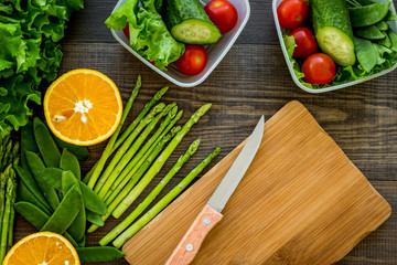 Healthy meal in containers. Salad with tomato and cucumber in cotainers on wooden background top view mockup