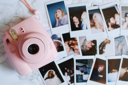 A pink camera and photographs