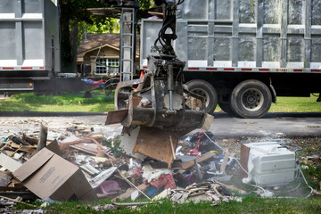Large truck picking up trash and debris outside of neighborhoods devastated by Hurricane Harvey 