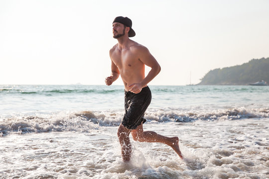Man running on the beach at sunset