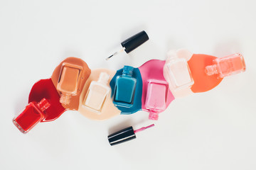 Nail polish bottles in puddles of nail polish liquid.