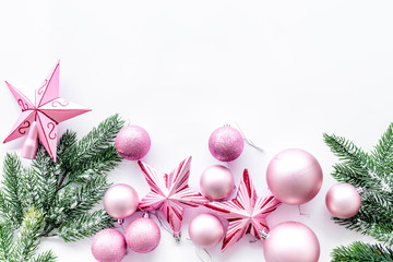 Christmas toys pattern. Pink stars and balls near pine branches on white background top view copyspace