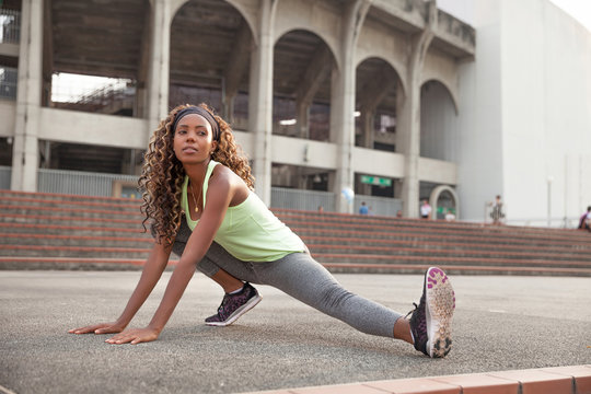 Black young woman stretching before the run