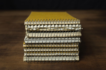 Old used reporter's notebooks stacked on a wooden table.