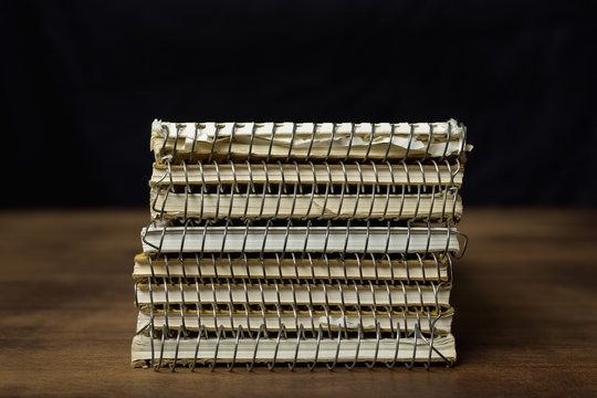 Stack of old used reporter's notebooks on a wooden table.