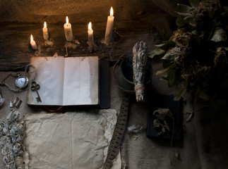 Magic fairytale table in the hut with window to the garden with open ancient book and burning...