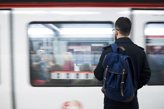 Young man standing in front of subway train
