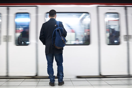 Young man standing in front of subway train