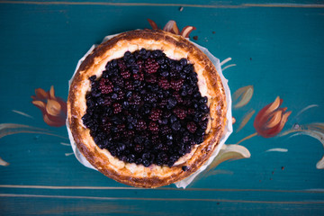 Pie with berries on a blue painted background