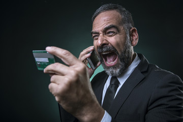 Crazy senior business man shouting over his phone on the bank manager, can't believe his credit...